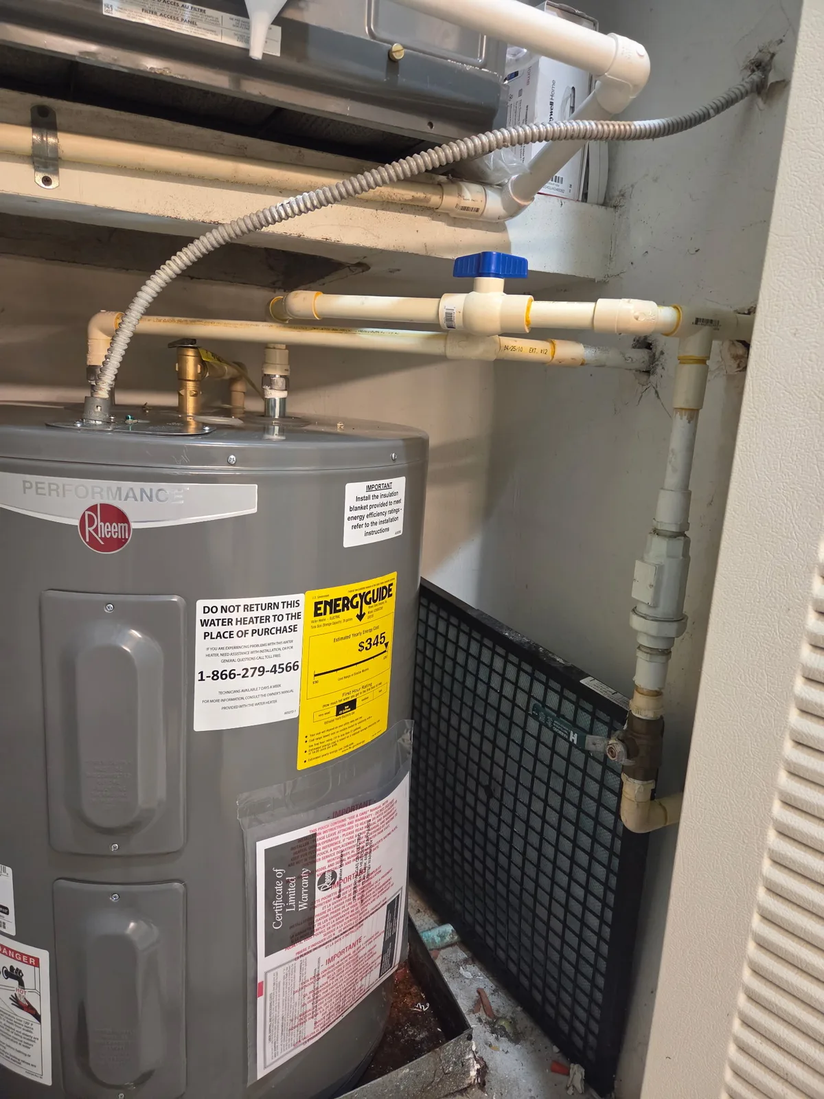 Electric water heater with copper supply lines and expansion tank in a utility closet
